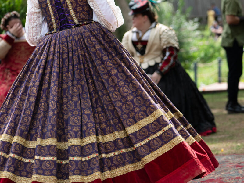 Queen Elizabeth's dress swings during a dance at a renaissance faire