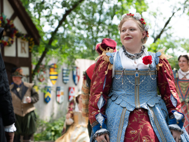 A lady smirks to the side during a renaissance faire