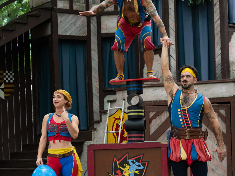 Acrobats laugh at the crowd during a renaissance faire show